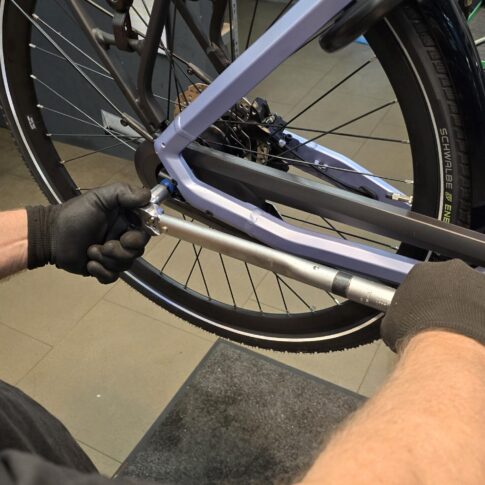 close up van een medewerker die bezig is met een fiets van een klant ebike gelderland