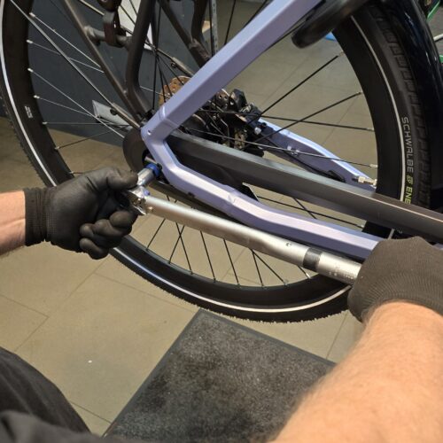 close up van een medewerker die bezig is met een fiets van een klant ebike gelderland