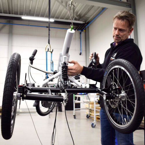 monteur die met een vanraam fiets bezig is om de suspensie van een easy rider weer in orde te krijgen ebike gelderland