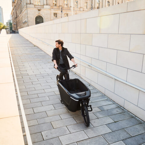 tenways cargo one man die op klinkers fietst buiten bij een kanaal ebike gelderland