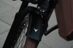 Koplamp en zwart voorspatbord boven de bruine band van de Levit BELECO Sports lowstep Woodrose.