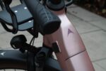Stuurhandvat en merkembleem op het roze frame van de Levit BELECO Sports lowstep Woodrose.