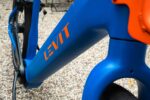 Oranje Levit-logo op het blauwe frame van de CAFE RIDER Ara.