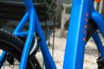 Blauwe zitbuis en achtervork met CAFE RIDER-modelnaam naast het ringslot.