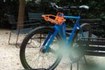 Blauwe Levit CAFE RIDER Ara met oranje voordrager op een terras met grind.
