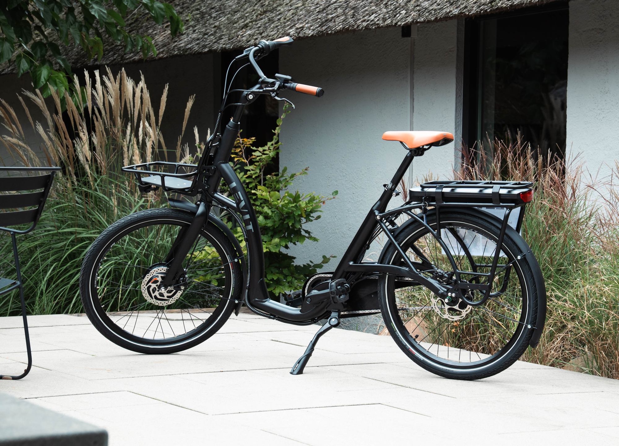 NSR-445 Zwarte Levit ZEN Obsidian e-bike met lage instap, voordrager en oranje zadel en handvatten.