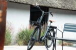 Zwarte Levit ZEN Obsidian op de standaard naast een terrasstoel.