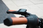 Stuurdisplay en oranje-zwarte handvatten van de Levit ZEN Obsidian, schuin van boven gezien.