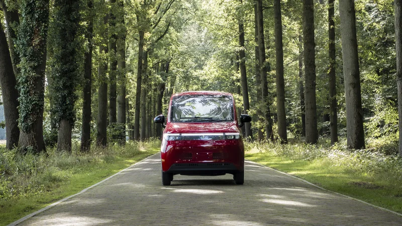 Rode Scheelen Skyliner op een weg tussen de bomen